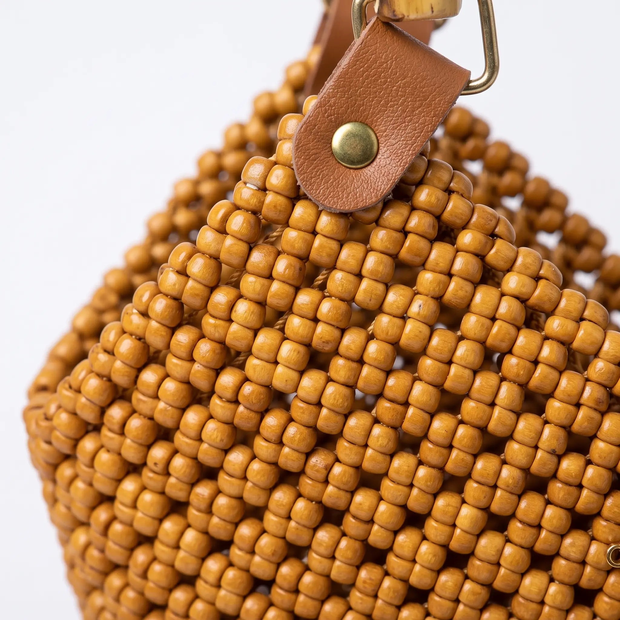 Natural bamboo handle and leather details on a handwoven PE rattan tote bag.